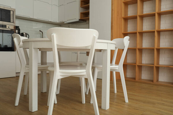 A round, white table with chairs in the kitchen