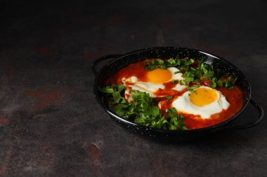 Koyu arkaplanda kızartma tavasında Shakshuka, metin için boşluk