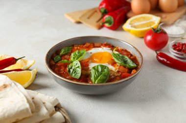 Fonda Shakshuka, baharatlar, domatesler, yumurtalar ve mutfak malzemeleri var.