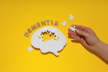 Sarı arka planda eksik elementleri olan bulmaca beyni