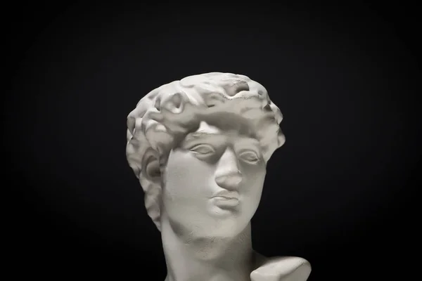 大卫的头在黑色背景上的石膏雕像 — 图库照片