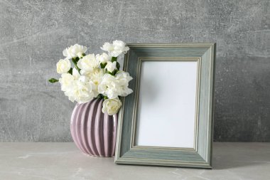 Masanın üzerinde boş alan olan çiçekli fotoğraf çerçevesi