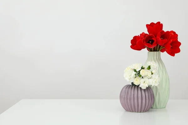 两个花瓶 桌上放着鲜花 上面有文字 — 图库照片