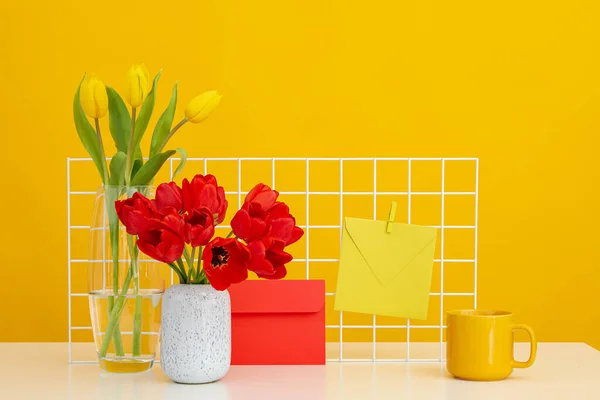 Üzerinde Çiçekler Mektuplar Sarı Bir Kupa Olan Bir Masa — Stok fotoğraf