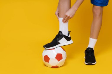 Siyah ayakkabılı, toplu bir gencin bacakları.