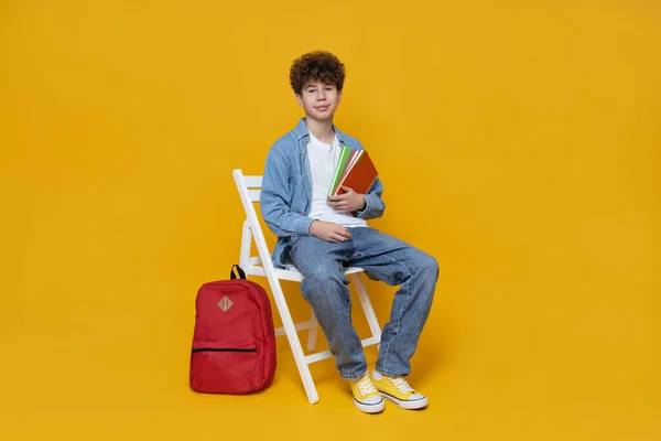 Šťastný Teenager Sedí Židli Žlutém Pozadí — Stock fotografie