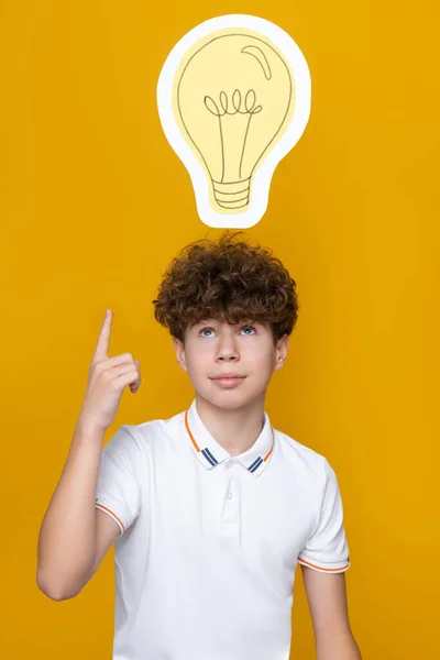 stock image A curly-haired teenager got an idea, a light bulb