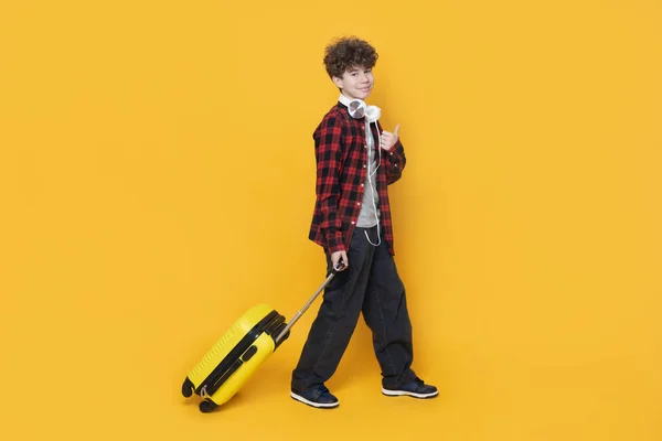 Een Tiener Met Een Koptelefoon Een Koffer Toont Een Vinger — Stockfoto