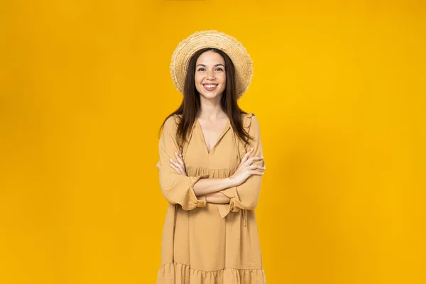 stock image A young woman in a beach hat is smiling on a yellow background