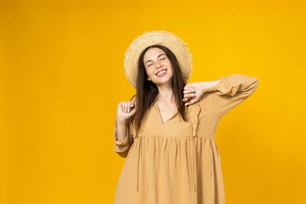 stock image A young woman in a beach hat is smiling on a yellow background