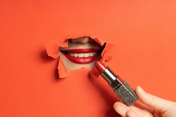 Stock image Close-up of female lips in torn paper hole with lipstick