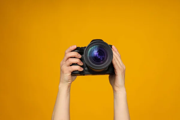Close Van Een Camera Handen Een Gele Achtergrond — Stockfoto