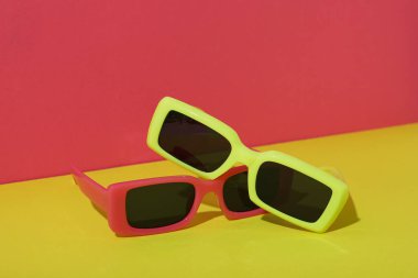 Red and yellow sunglasses on red and yellow background clipart