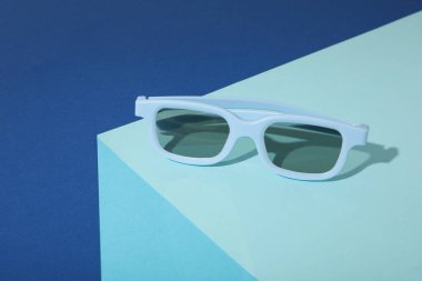 Mavi masada mavi güneş gözlüğü ve koyu mavi arka plan