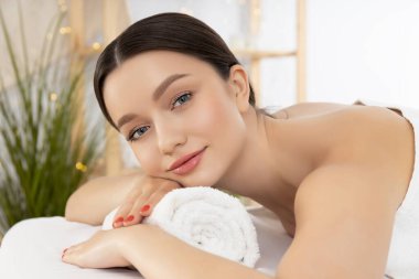 Gülümseyen genç bayan masajda, hafif arka plan, yakın çekim