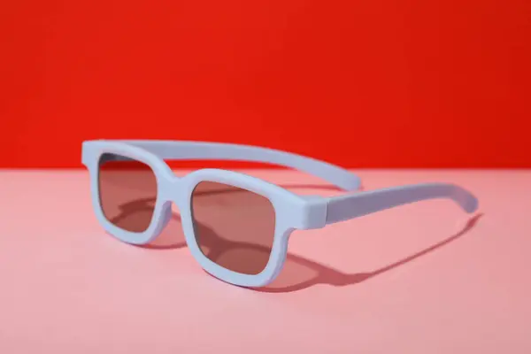 Light Blue Sunglasses Pink Table Red Background — Stock Photo, Image