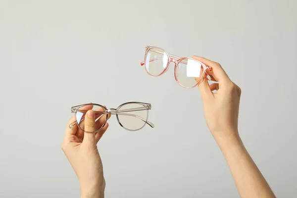 Óculos Mãos Femininas Sobre Fundo Cinza Claro — Fotografia de Stock