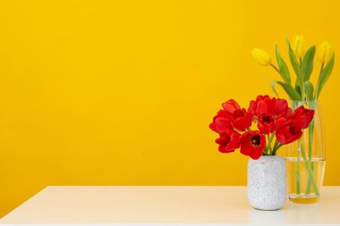 Sarı arkaplanda laleli vazolar, metin için yer var.