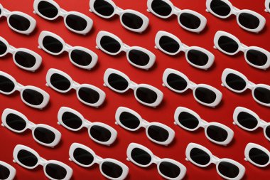 Kırmızı zemin üzerinde güneş gözlüğü, üst görünüm