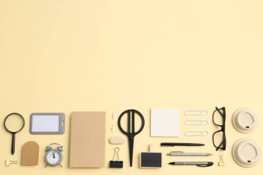 Saat yönünde kırtasiye modeli, gözlük ve bej arkaplan üzerinde farklı kırtasiye malzemesi, metin için boşluk