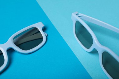 Mavi arka planda koyu lensli mavi gözlükler.