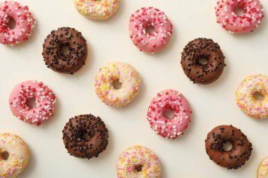 Çikolata, beyaz ve pembe donutlar beyaz arka planda, üst manzara