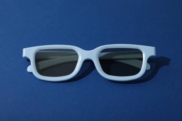 Jasnoniebieskie Okulary Przyciemnianymi Soczewkami Ciemnoniebieskim Tle — Zdjęcie stockowe