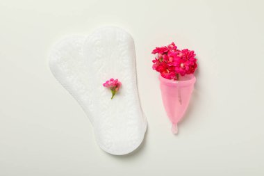 Adet pedi ve beyaz arka planda çiçekli bir fincan.