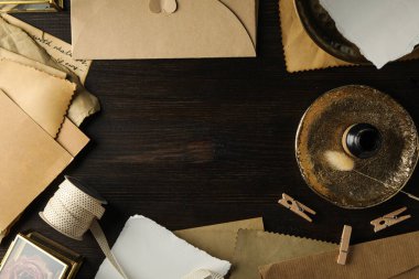 Kaliteli mektuplar, altın tabak ve ahşap arka planda mürekkep şişesi, metin için yer