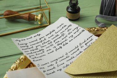 Altın tepside yazı, mürekkep şişesi ve yeşil ahşap arka planda damga, kapat
