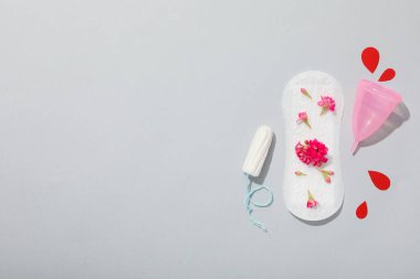Gri arka planda çiçekler olan adet yastığı.