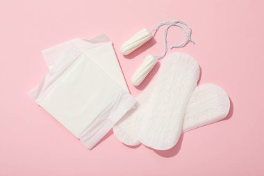 Pembe arka planda adet görmüş kadın hijyen ürünleri.