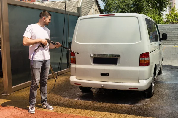 stock image A man washes a car at a self-service car wash