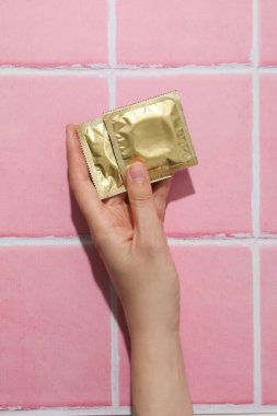 Pembe arka planda kondomlar.
