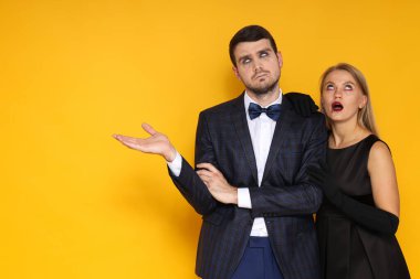 Cadılar Bayramı kostümlü bir kız ve bir oğlan sarı arka planda