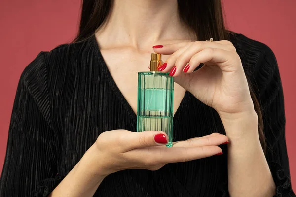 Butelka Perfum Rękach Młodej Kobiety Różowym Tle — Zdjęcie stockowe