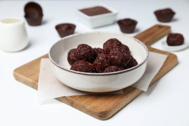 Brigadeiro beyaz arka planda mutfak tahtasındaki kasede.