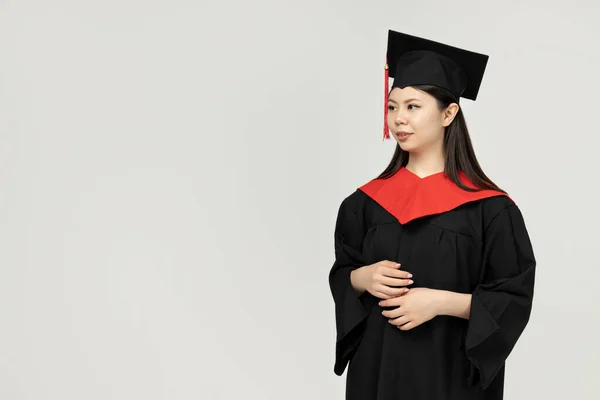 Ein Mädchen Asiatischen Aussehens Ein College Absolvent Auf Grauem Hintergrund — Stockfoto
