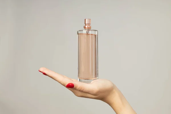 白い背景に女性の手の香水瓶 — ストック写真