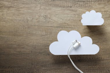 Beyaz, kağıt bulutlar beyaz USB kablo ile ahşap arka planda, metin için yer
