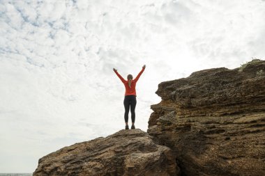 Kız doğada yoga yapıyor, deniz kenarında.