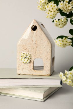 Seramik ev kitaplarda ve çiçekler beyaz arka planda