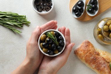 Zeytinler kasede kadın ellerinde, baget ve kavanoz beyaz arka planda, üst manzara