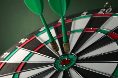 Dartlar yeşil arka plandaki kablolarla hedefi vuruyor. Kapat..