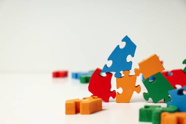 Beyaz arka planda çok renkli yapboz parçaları, metin için yer. Dünya otizm günü konsepti