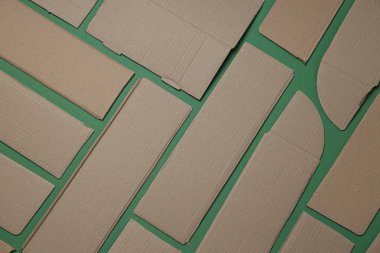 Yeşil arka planda yırtık bir karton, üst manzara. Çöp geri dönüşüm kavramı.