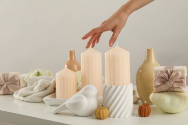 Mumlar, vazolar ve arka plandaki kadın eli.