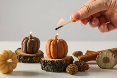 Mumlar ahşap tezgahlarda ve eller hafif arka planda