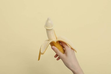 Kondomu muza ver, elinde hafif arka planda olsun.