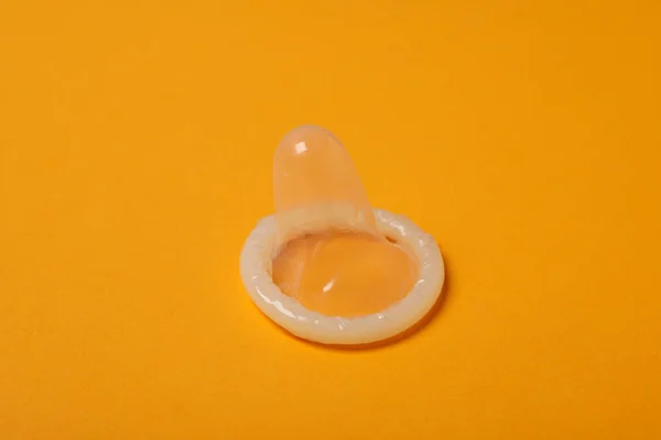 Zbliżenie Rozpakowanej Prezerwatywy Żółtym Tle — Zdjęcie stockowe